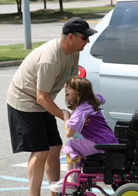 Father helping daughter into automobile